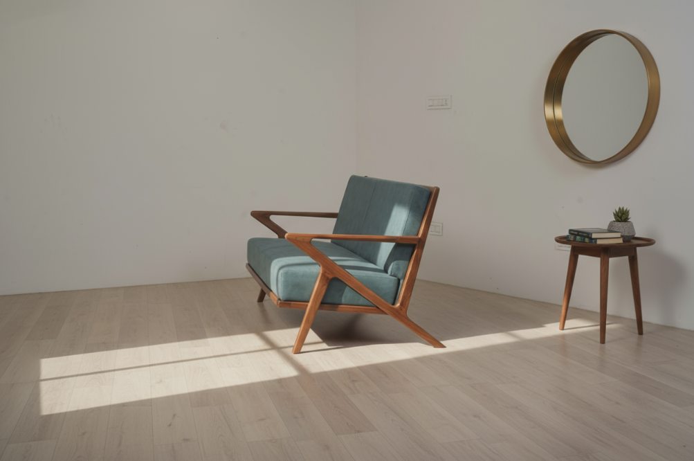 Teal lounge chair on a teak Z-frame in a sunlit room